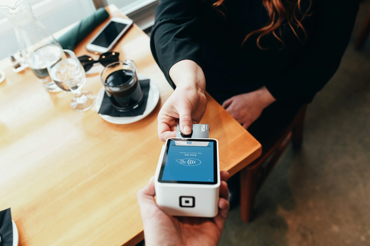 A card payment being tapped on a point-of-sale terminal