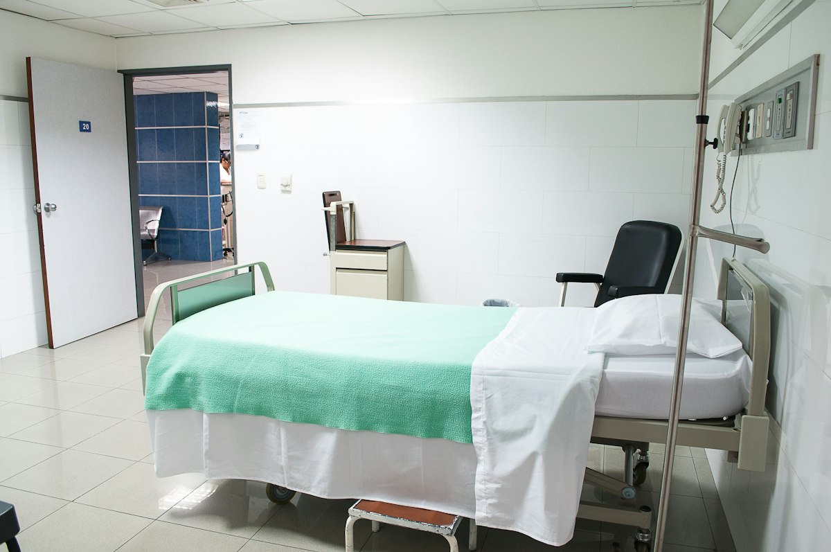 An empty, made-up hospital ward bed