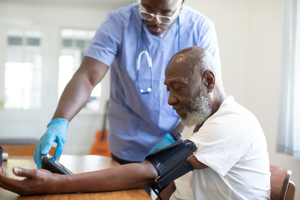 A nurse checking a patient's blood pressure during a consultation