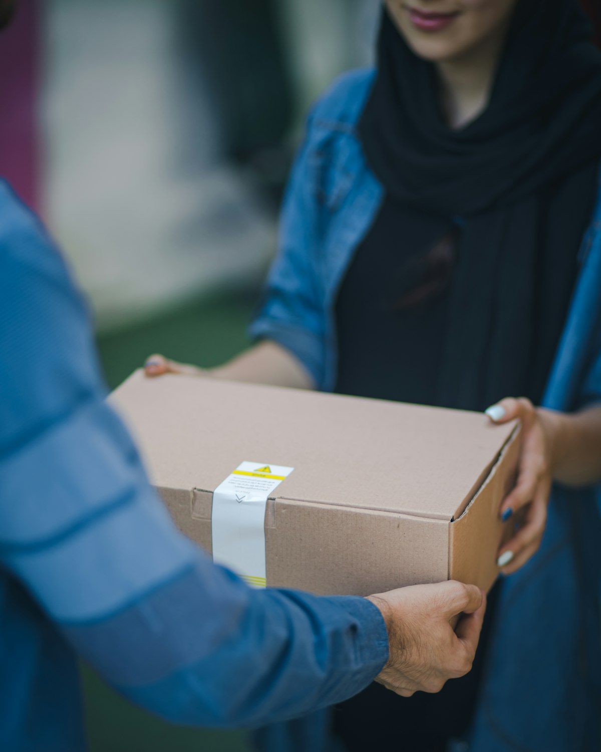 A courier handing a delivery package to a customer