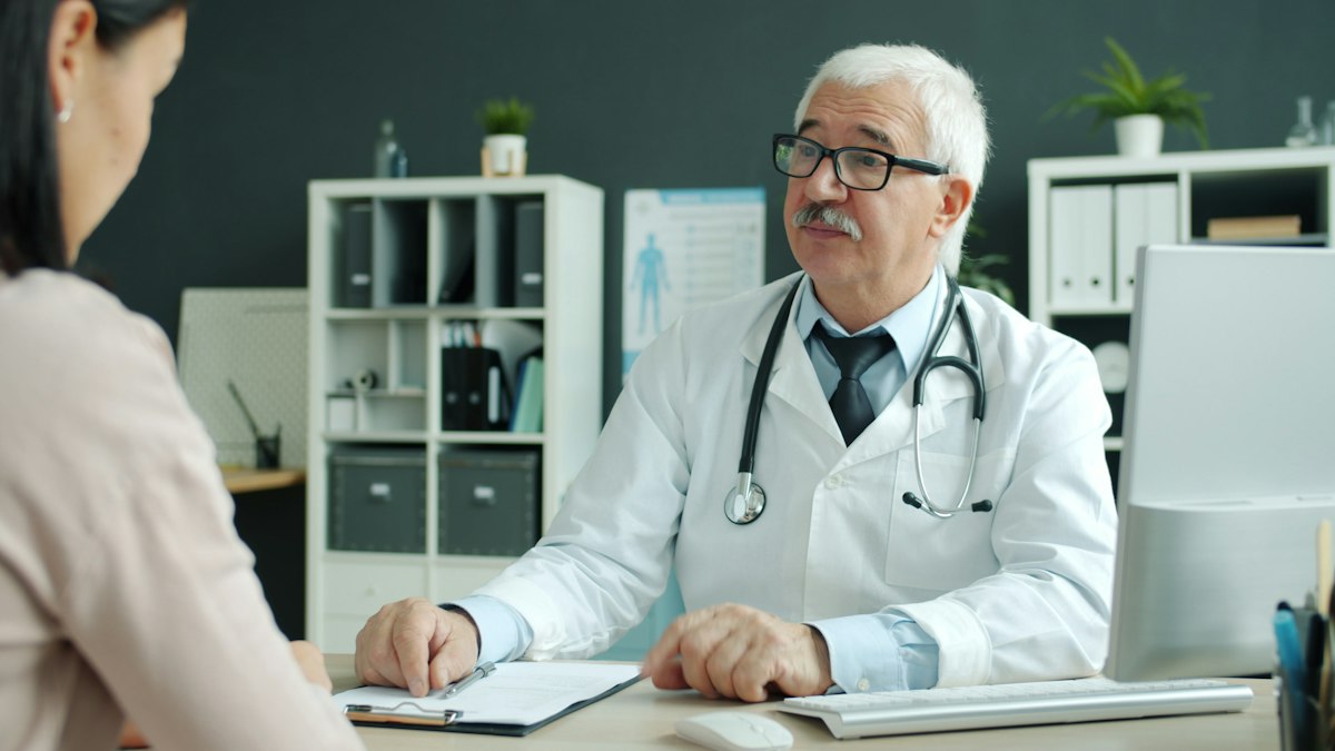 A doctor consulting with a seated patient